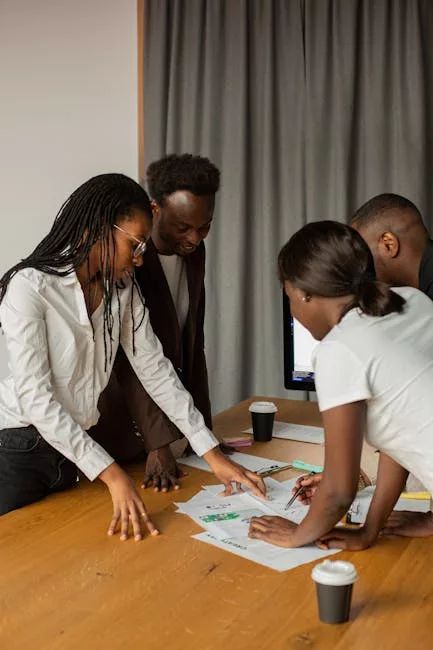A diverse group of professionals engaged in a brainstorming session around a work table.